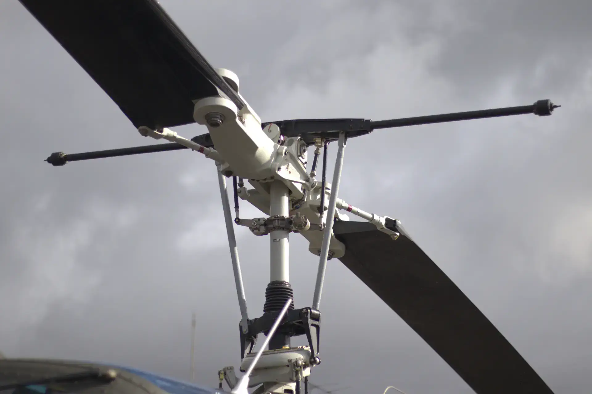 Close-up of a helicopter's rotor assembly against a cloudy sky.