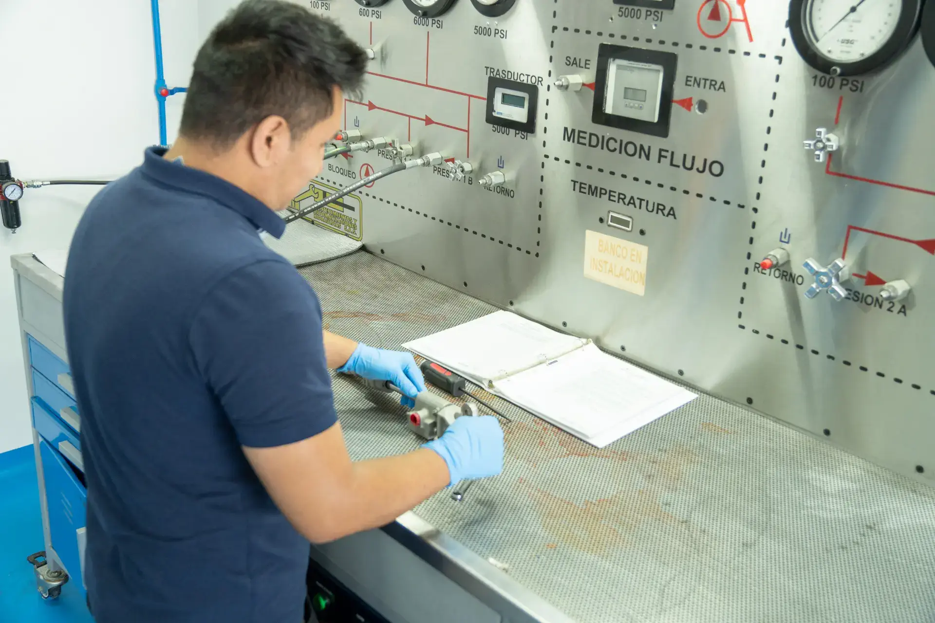 A person works with equipment in a lab with various pressure and flow measurement devices.